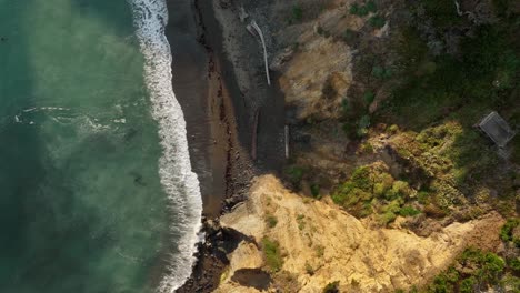 Lowering-aerial-view-of-a-private-beach-off-of-California's-coastline