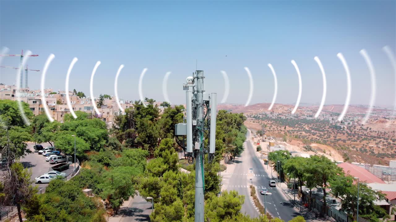 Cell Tower with Signal Radiating Over Urban Landscape