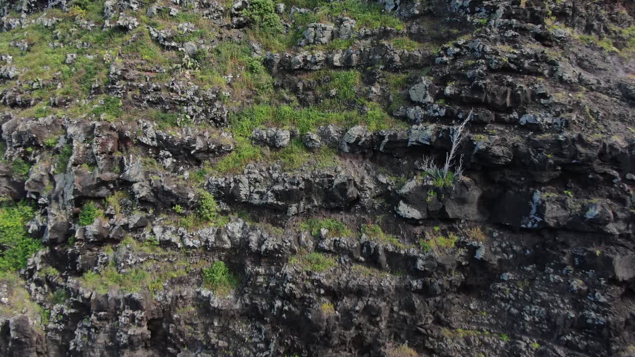 снимок с воздуха, на котором видны черные и суровые вулканические скалы маяка макапу'у поинт на оаху