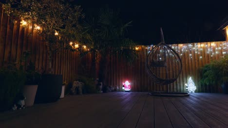 imágenes al aire libre de un jardín minimalista por la noche con iluminación cálida, luces de hadas y decoraciones navideñas
