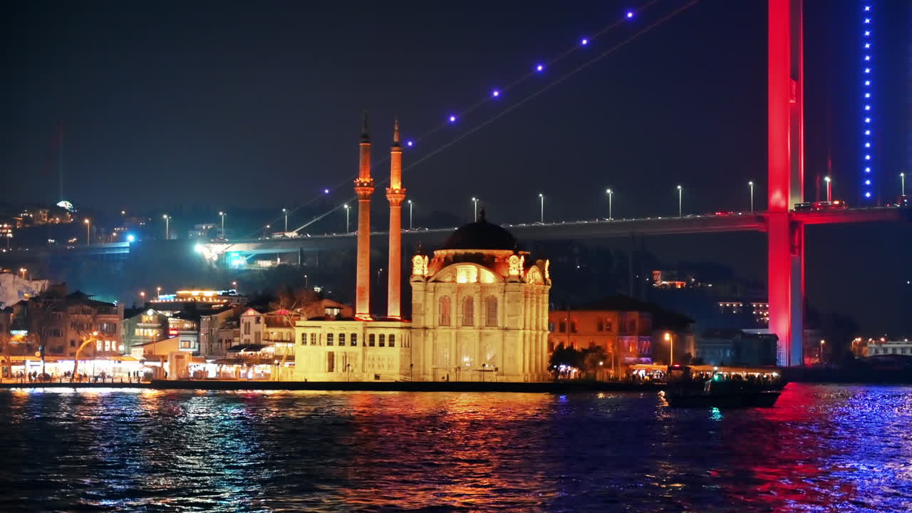 Vista do Estreito de Bósforo à noite em Istambul, Turquia. Mesquita de Nusretiye, ponte iluminada com carros e edifícios no plano de fundo