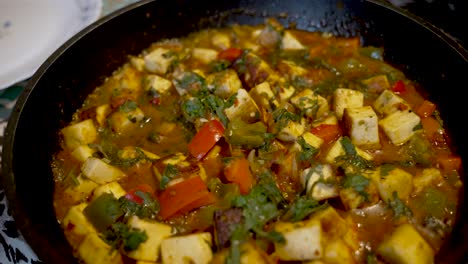 tasty spice paneer curry dish with red and green peppers in pan