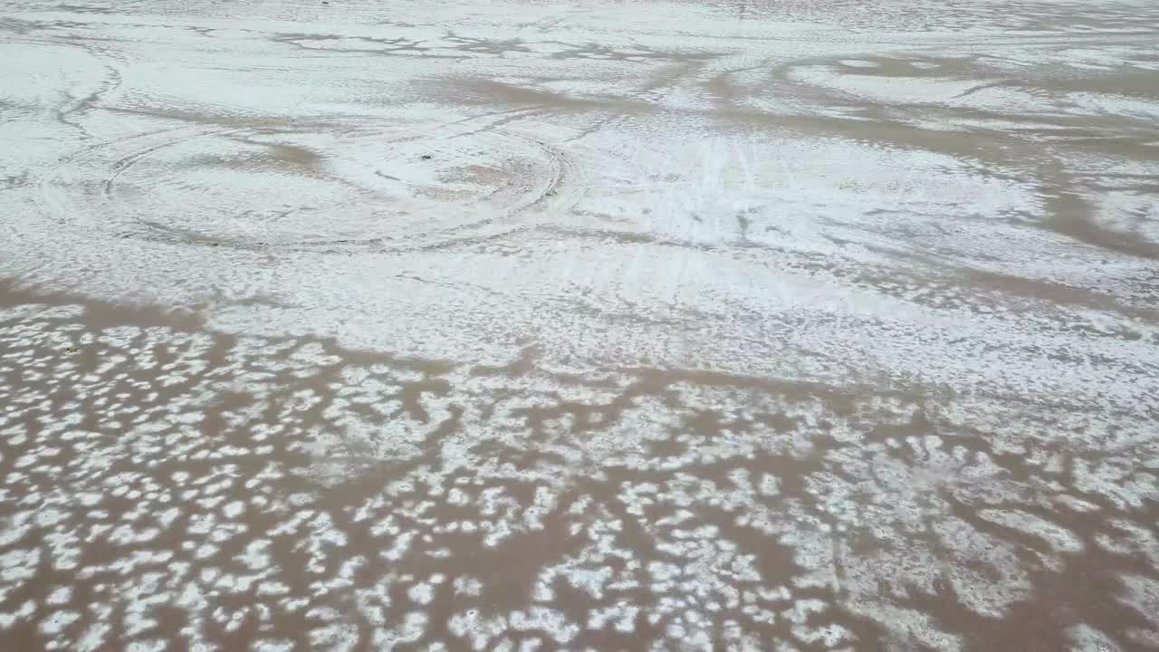 Salt Flat and Vehicle Trails. Pull Back Drone Aerial of Surreal Landscape, Salinas Grandes, Argentina