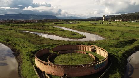 drone shot flying above a round fort, landmark theater in bogota