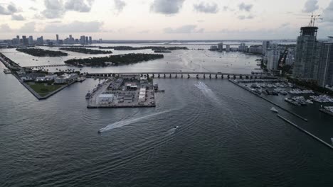 aerial of miami south beach with fast boat cruising the sea and skyline skyscraper building
