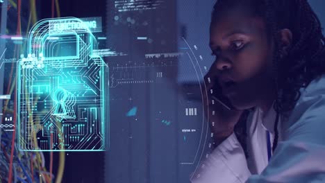 Animation-of-data-processing-and-padlock-over-african-american-woman-working-in-server-room