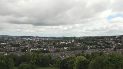 imágenes de drones desde el parque sobre los árboles revelando los suburbios de sheffield