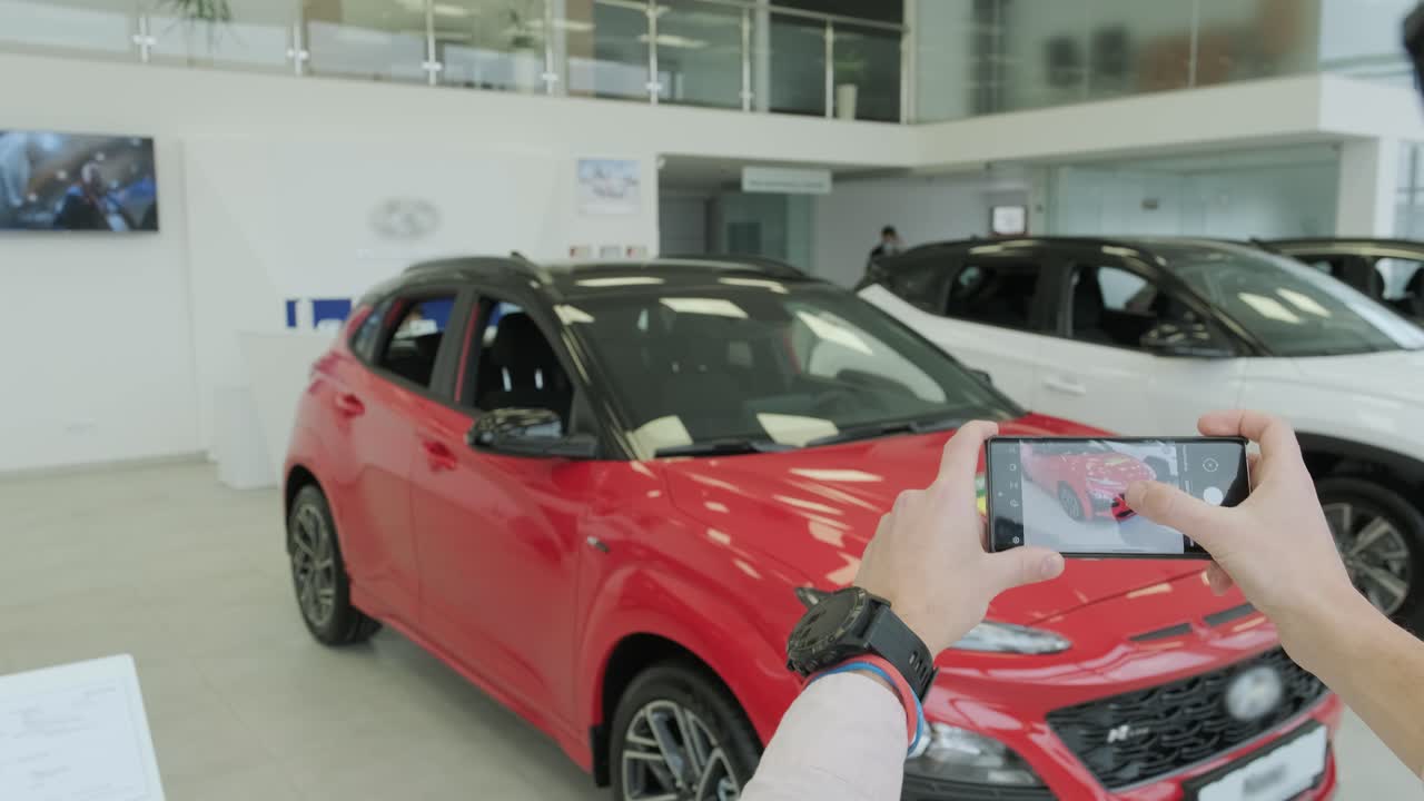el gerente del concesionario toma fotos de un coche nuevo para la venta. sala de exhibición de coches nuevos de prestigio.