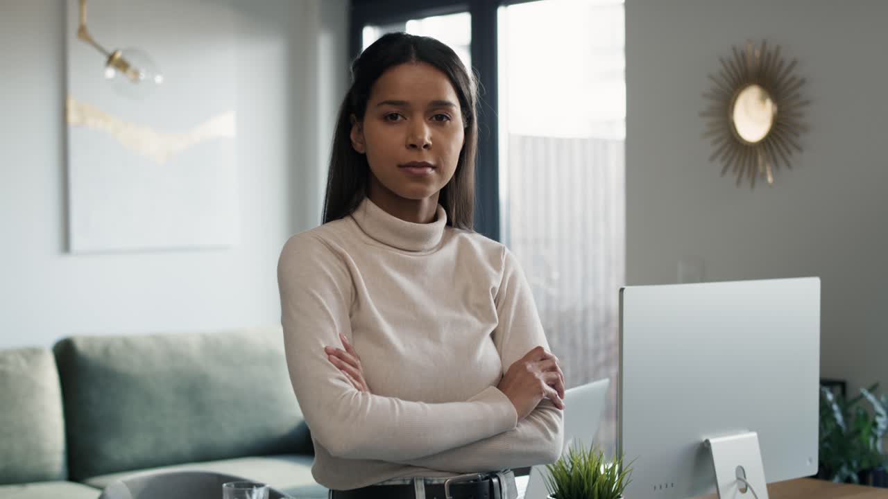 retrato de una mujer de raza mixta de pie al lado del escritorio en casa