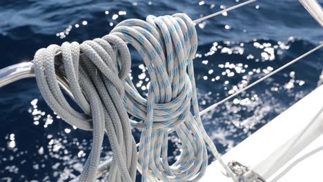 close-up view of sailboat ropes at sunny weather, pulleys and ropes on the mast, yachting sport, ship equipment, sea is on background