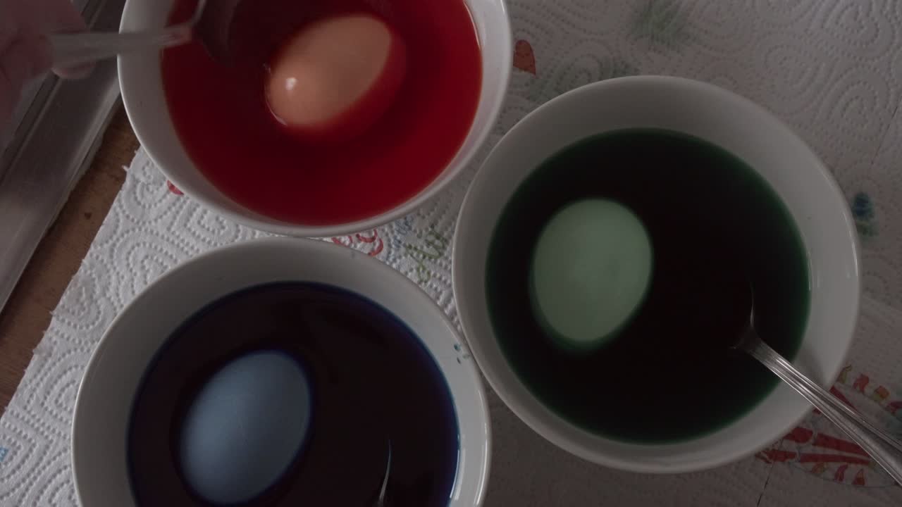 Painting eastern eggs in a bowl of water with different colors