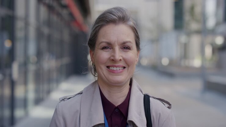 ritratto professionista donna d'affari matura sorridente che gode di uno stile di vita urbano felice in città in slow motion