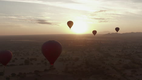 hot air balloons floating in the sky during a beautiful golden sunrise