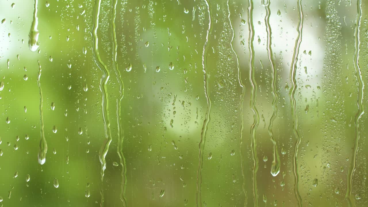 Nature water rainfall, rain drops texture on window glass, blurred green trees