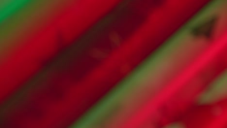 extreme close-up christmas wrapping paper rolls slow motion rack unfocus, vibrant red green two-light
