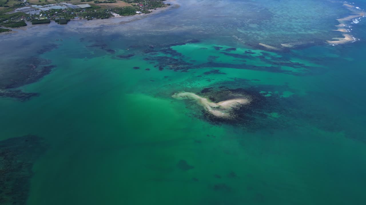 Vista aerea ad ampio orizzonte delle isole Tondol, circondate da acque calme e verde-azzurre e con uno scenario costiero tropicale.