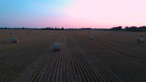 Flying-Above-the-Field-With-Hay-Rolls-Sunrise