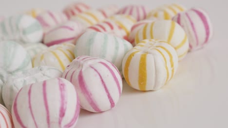 pile of striped sugar bonbons on white close-up 4k video