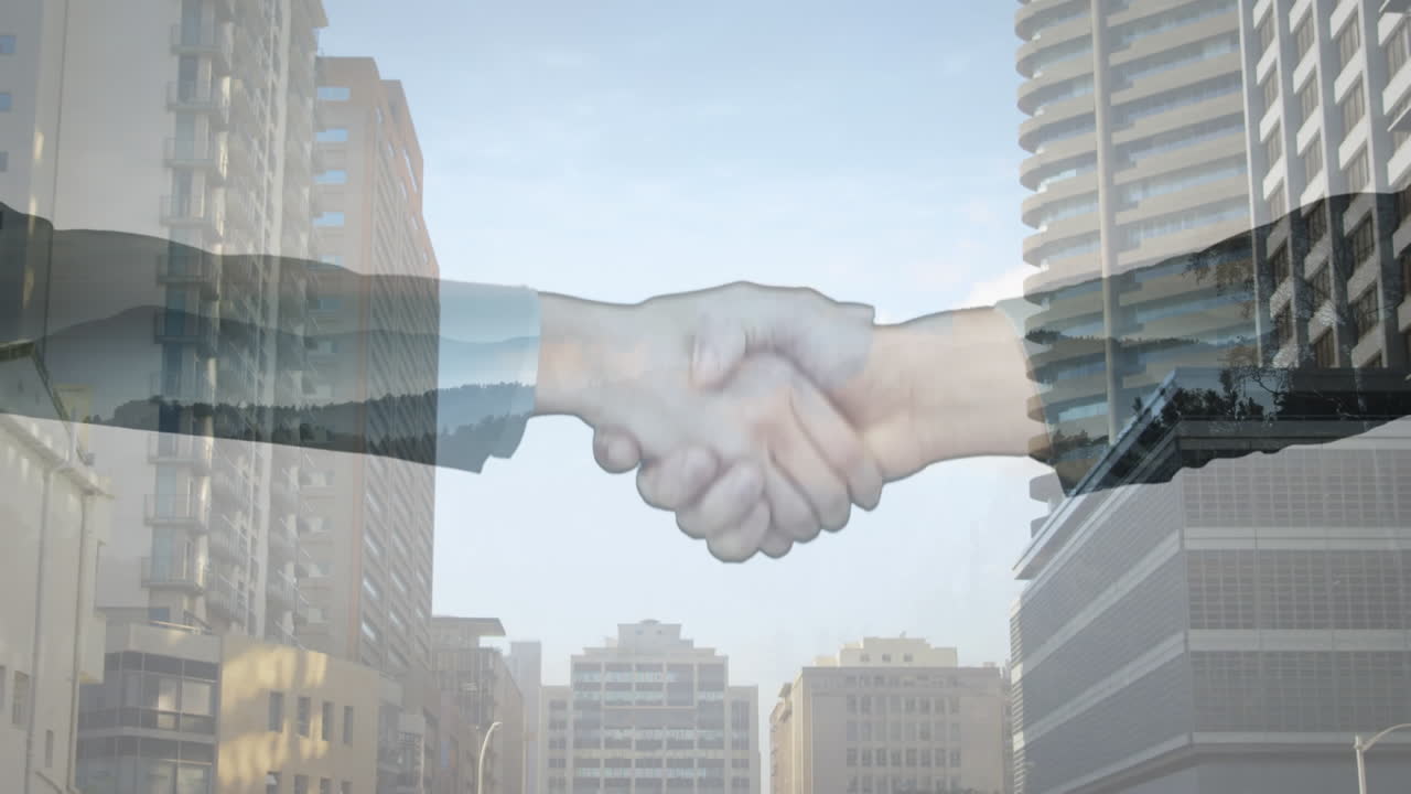 Sección media de un empresario y una empresaria dándose la mano con edificios altos de fondo