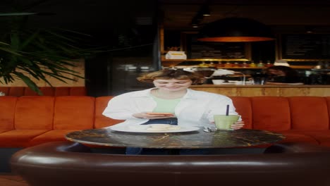 woman using phone in a cafe