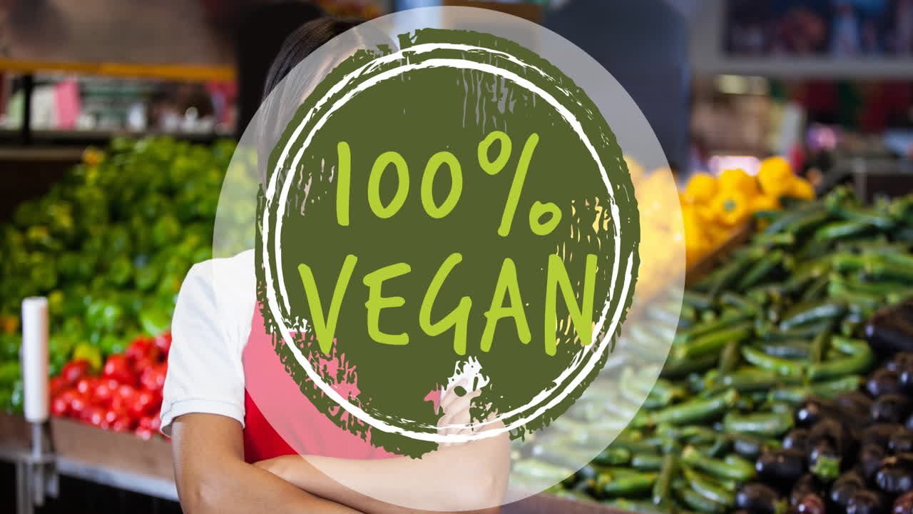 Animación de texto "100% vegano" en verde, sobre una mujer sonriente frente a verduras en una tienda.