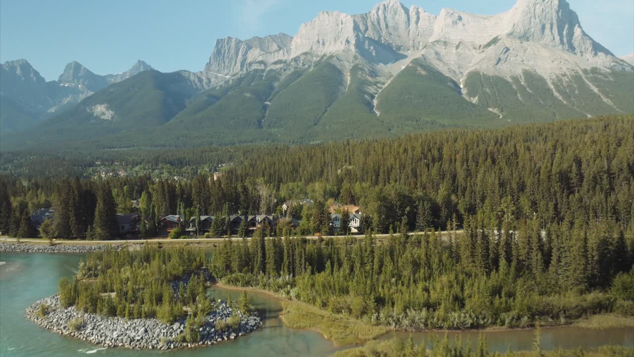 높은 상록 나무 와 숲 에 있는 집 들 으로 둘러싸인 강 의 파란 물