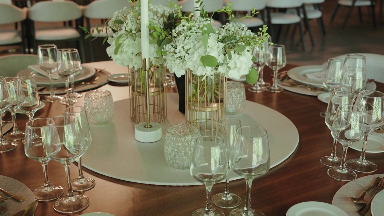 Description:
Round table set with wine glasses plates and white flower centerpiece
