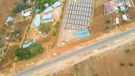 Foque-Hacia-Abajo-De-Una-Granja-De-Paneles-Solares-En-África-Rural--Energía-De-Renovación-Verde-ODS--Granja-Fotovoltaica-De-Células-De-Paneles-Solares