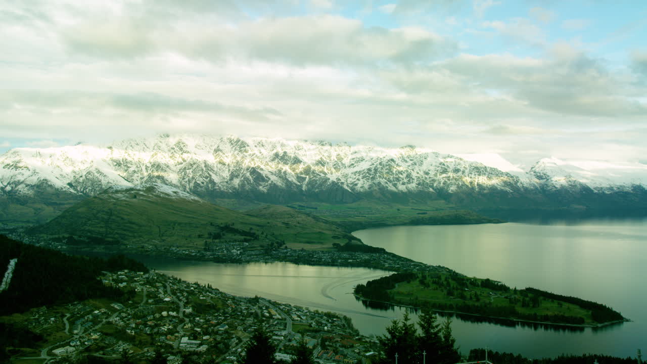 Queenstown lakeside town surrounded by snow cap mountains in New Zealand Time Lapse.
