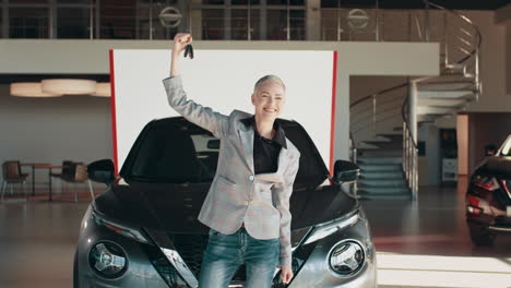 woman celebrating new car purchase at dealership