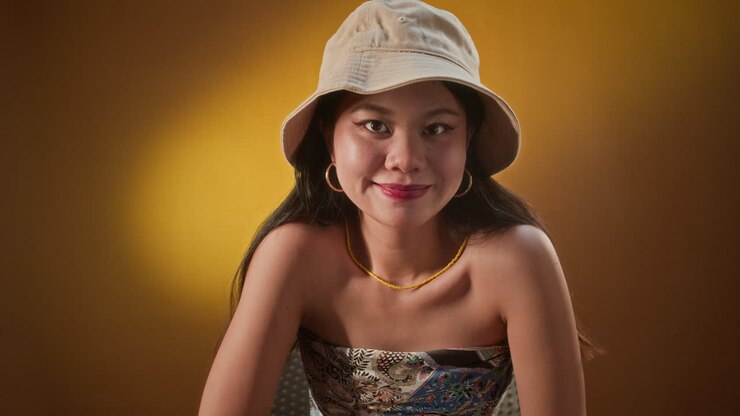 Ritratto di ragazza asiatica che balla seduta su una sedia, illuminazione LED gialla
