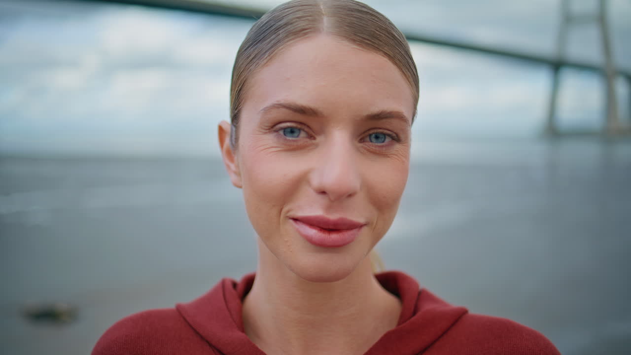 Portrait smiling sportswoman posing at ocean bridge. Happy fitness woman resting