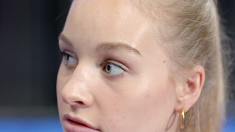 young woman looking sideways with thoughtful expression during padel tennis match, at indoor court