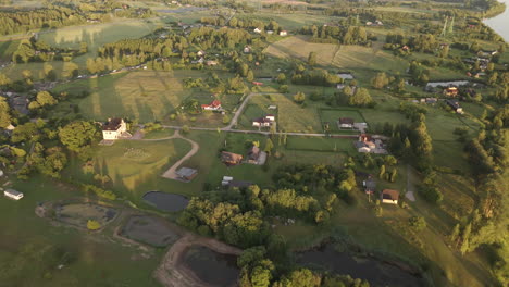 drone aerials: capturing a picturesque countryside village by the daugava river at golden hour