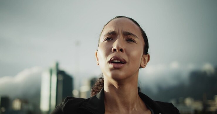 Exhausted Young Woman Resting After Running in the City