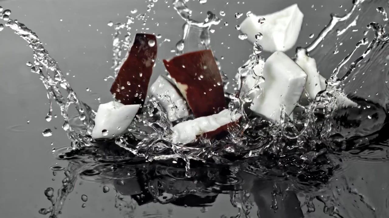 Pezzi di cocco che cadono nell'acqua al rallentatore