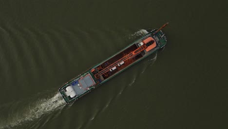 aerial topdown view of vessel ship with crane floating on water in static shot