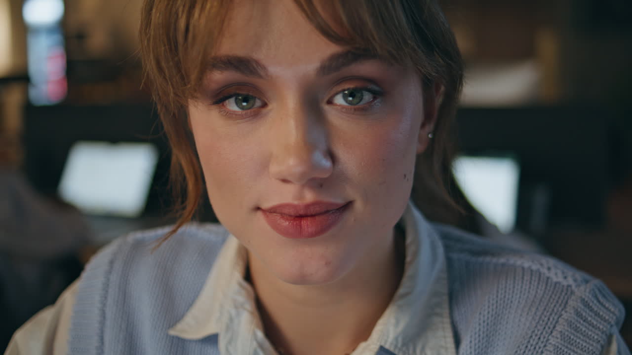 Smiling manager looking camera at evening workplace portrait. Happy woman posing