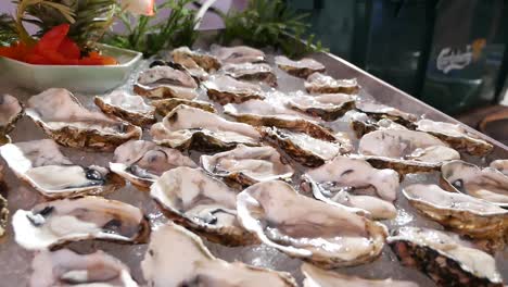 fresh raw oyster in half shell display on ice, close up