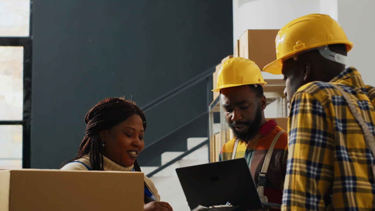 Warehouse workers discussing work with tablet and boxes