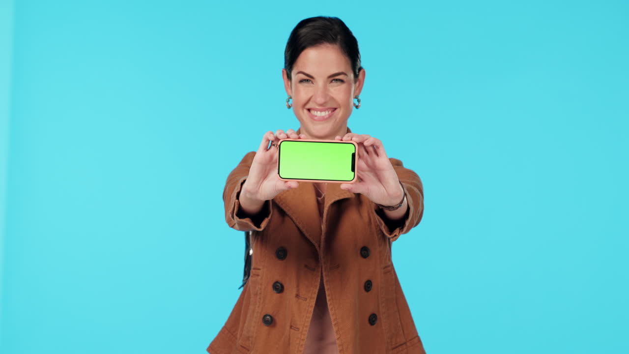 mujer sosteniendo un teléfono inteligente con pantalla verde