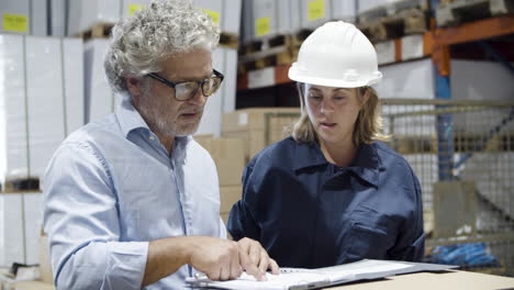 focused supervisor and female employee talking in warehouse