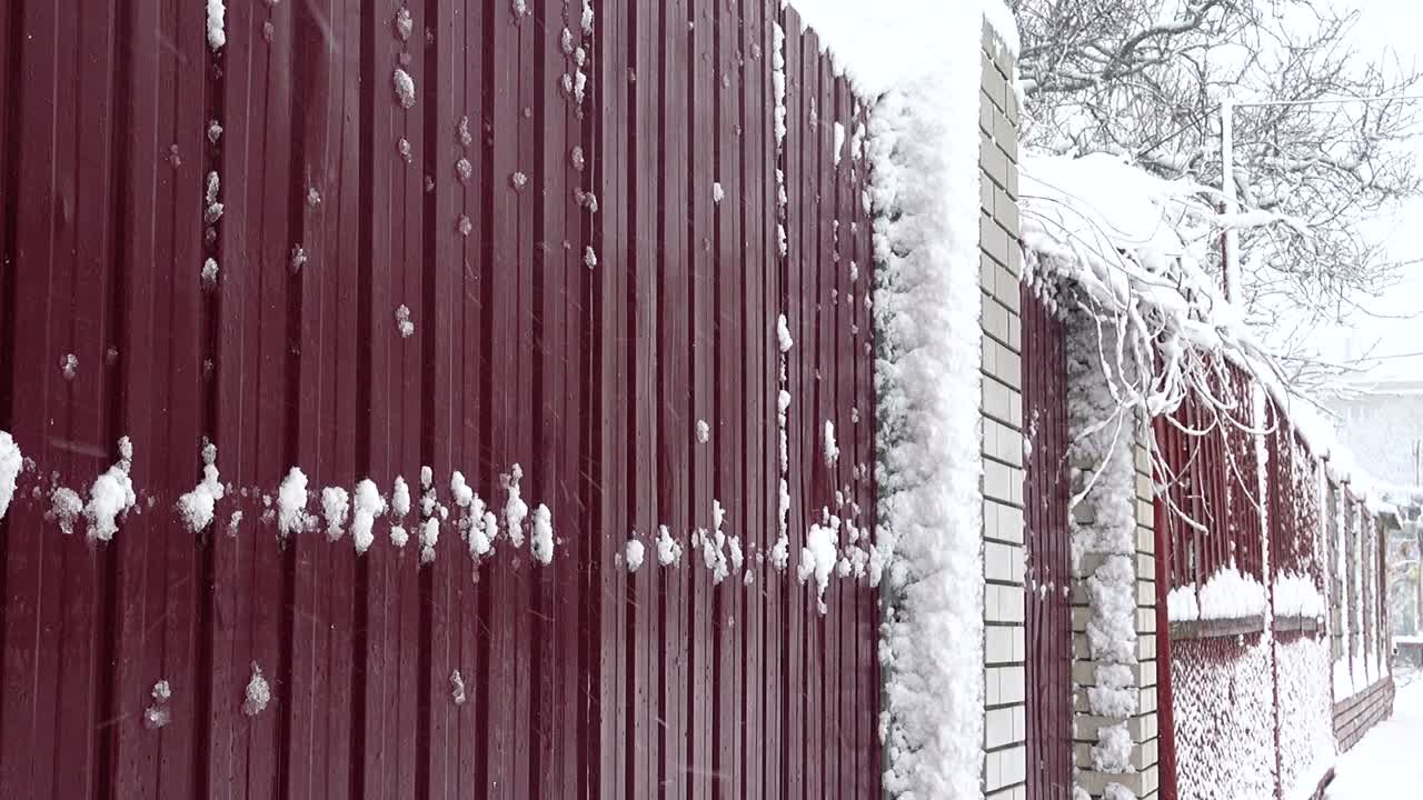 Neve sullo sfondo di una recinzione. Neve in città. Riprese in inverno.