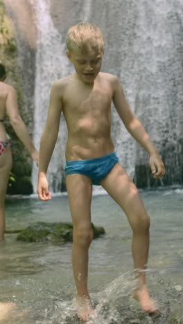 boy playing in a waterfall