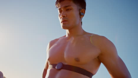 asian man, earphones and tired by beach