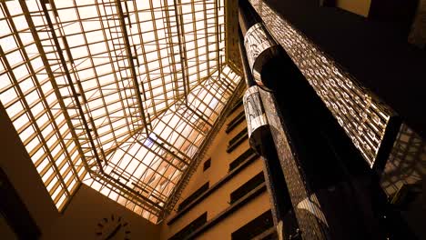 modern hotel atrium with glass elevator and skylight