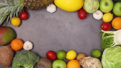 organic fruits and vegetables making healthy frame with copy space on dark background. stop motion