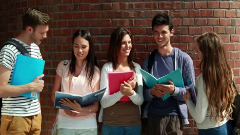 Happy-classmates-standing-and-studying-together--