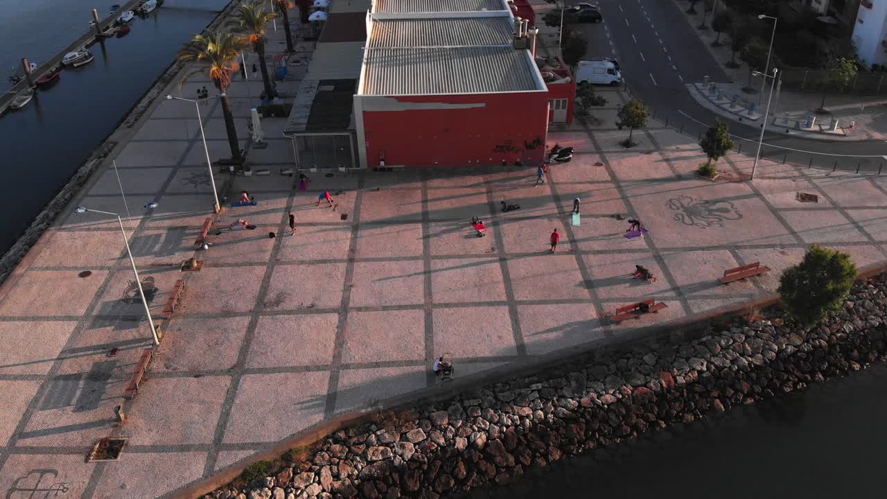 Group of people participating in a bootcamp on the riverside in Portimao, aerial