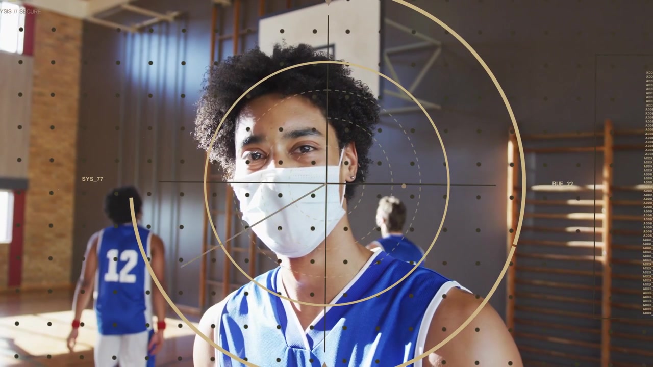 Jogador mascarado segurando uma bola de basquete e girando, enquanto a câmera esportiva recua, com sobreposição rastreando a bola.